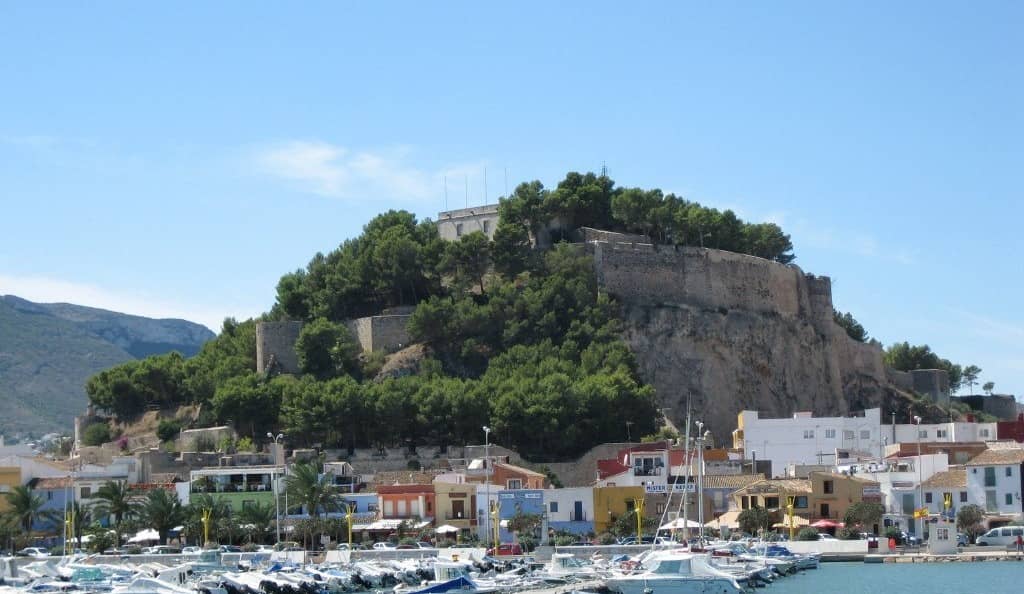 El castell de Dénia damunt del port i les barques de pesca