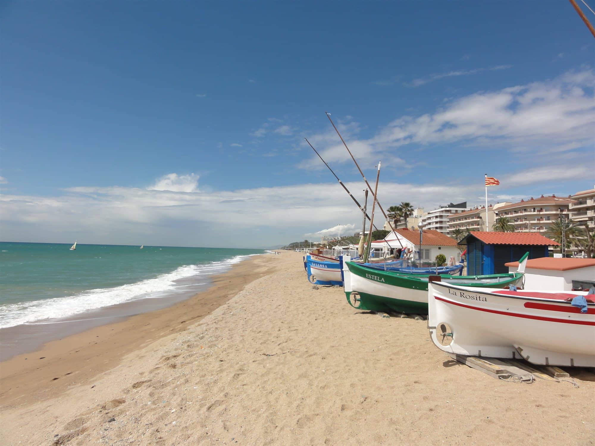 Die Platja dels Pescadors in Pineda de Mar: Fischerboote auf dem Sand und die Promenade