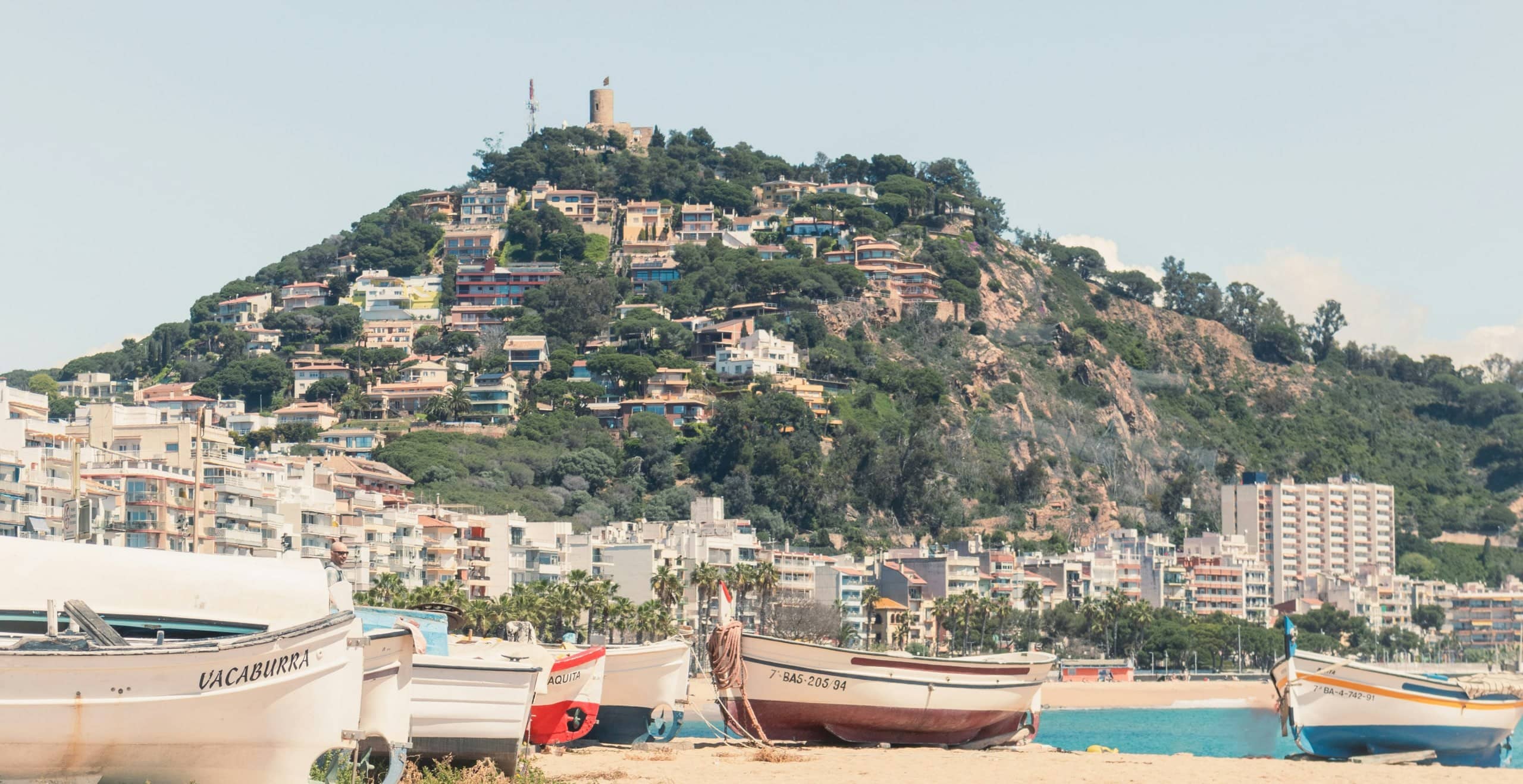 Fischerboote am Strand von Blanes, auf dem Hügel die Burg Sant Joan