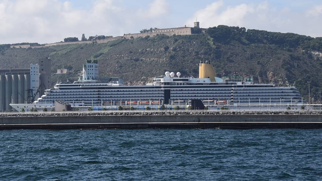 A cruise ship at its berth in the port of Barcelona below Montjuïc