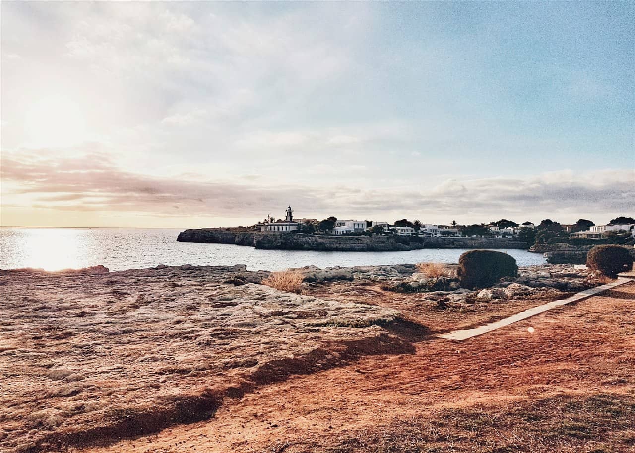 Far en un cap rocós i cases blanques vora el mar