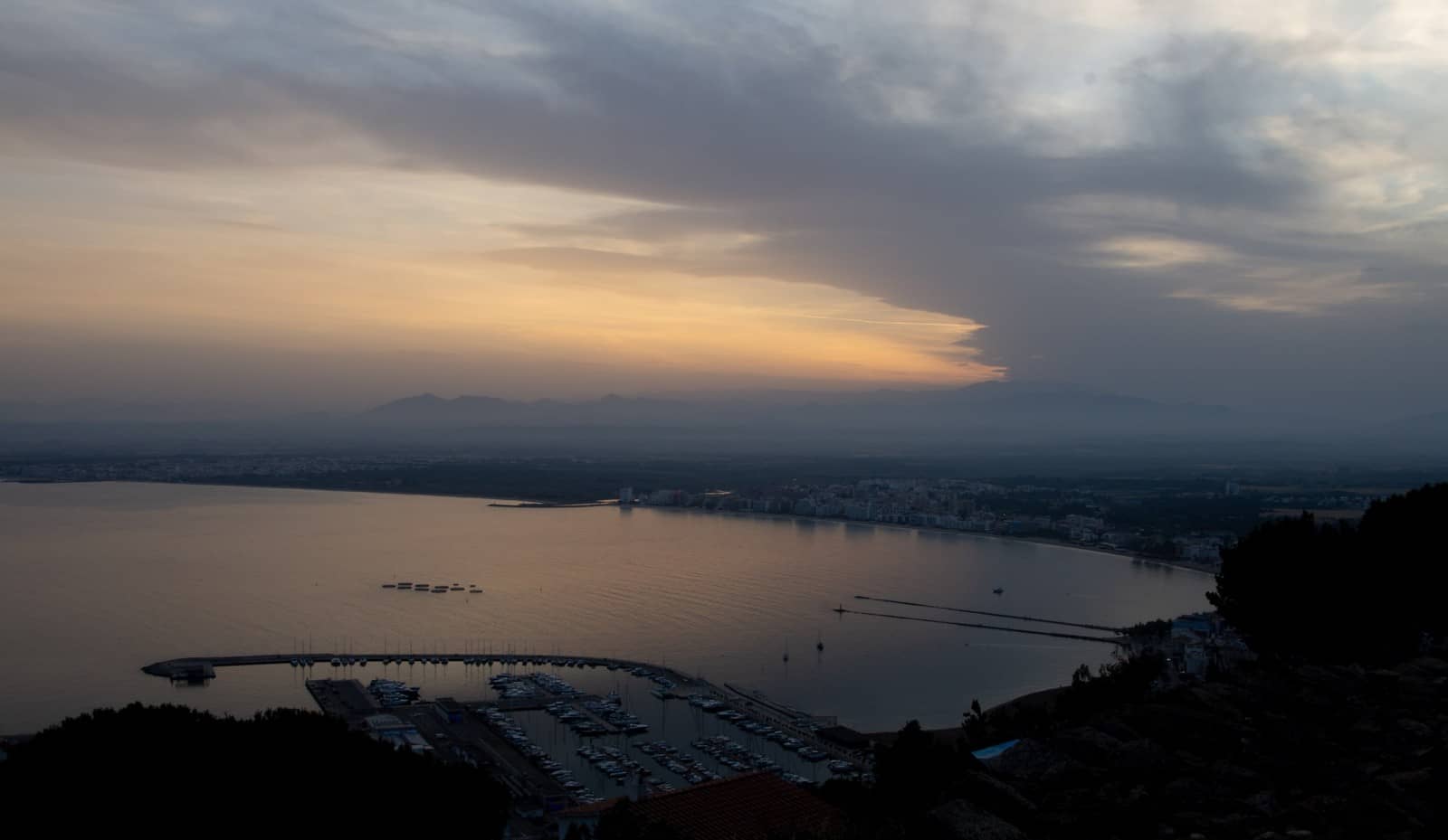 La badia de Roses i el port esportiu a la posta de sol