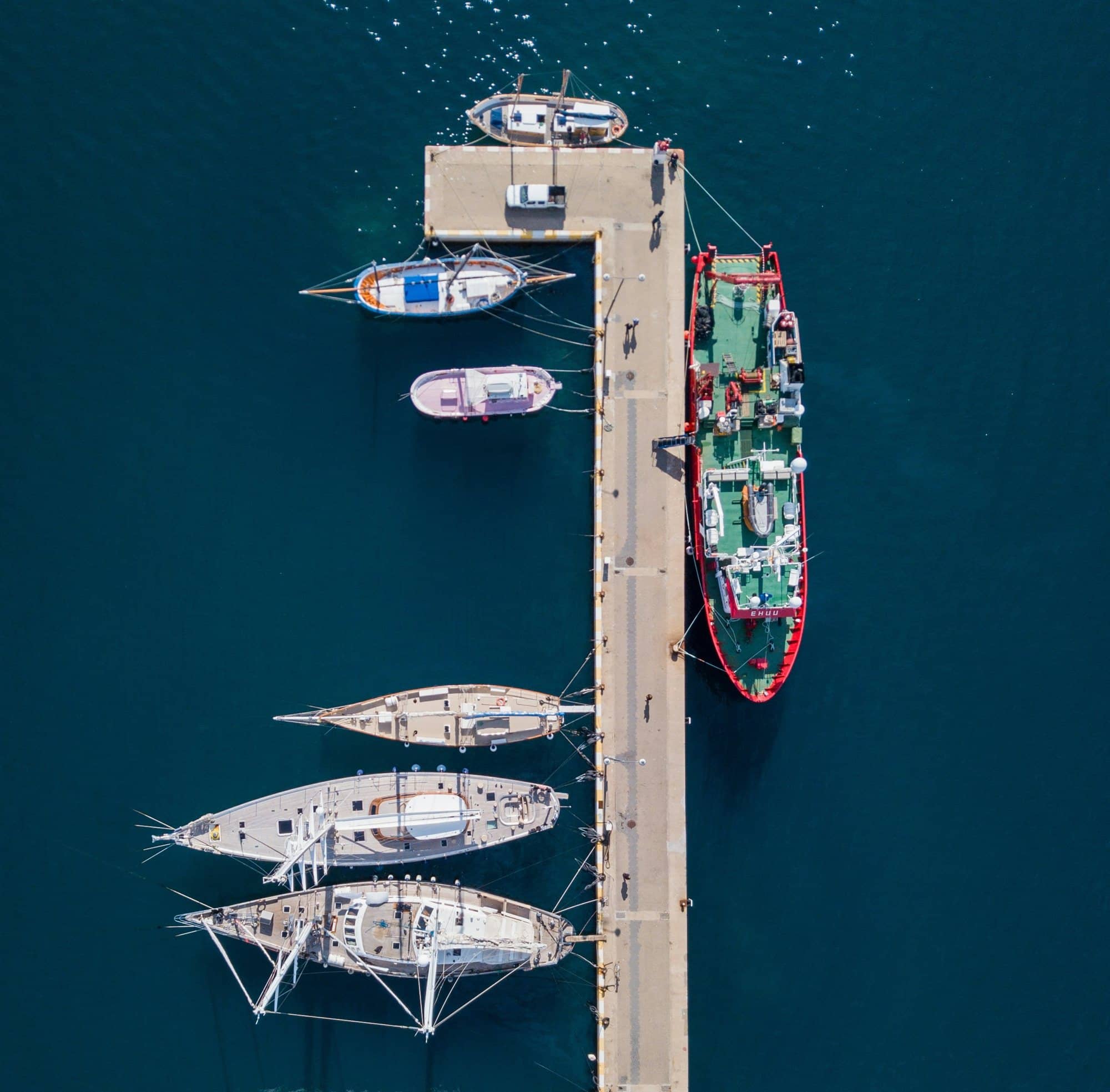 El port de Palamós des de dalt: barques de pesca i velers amarrats