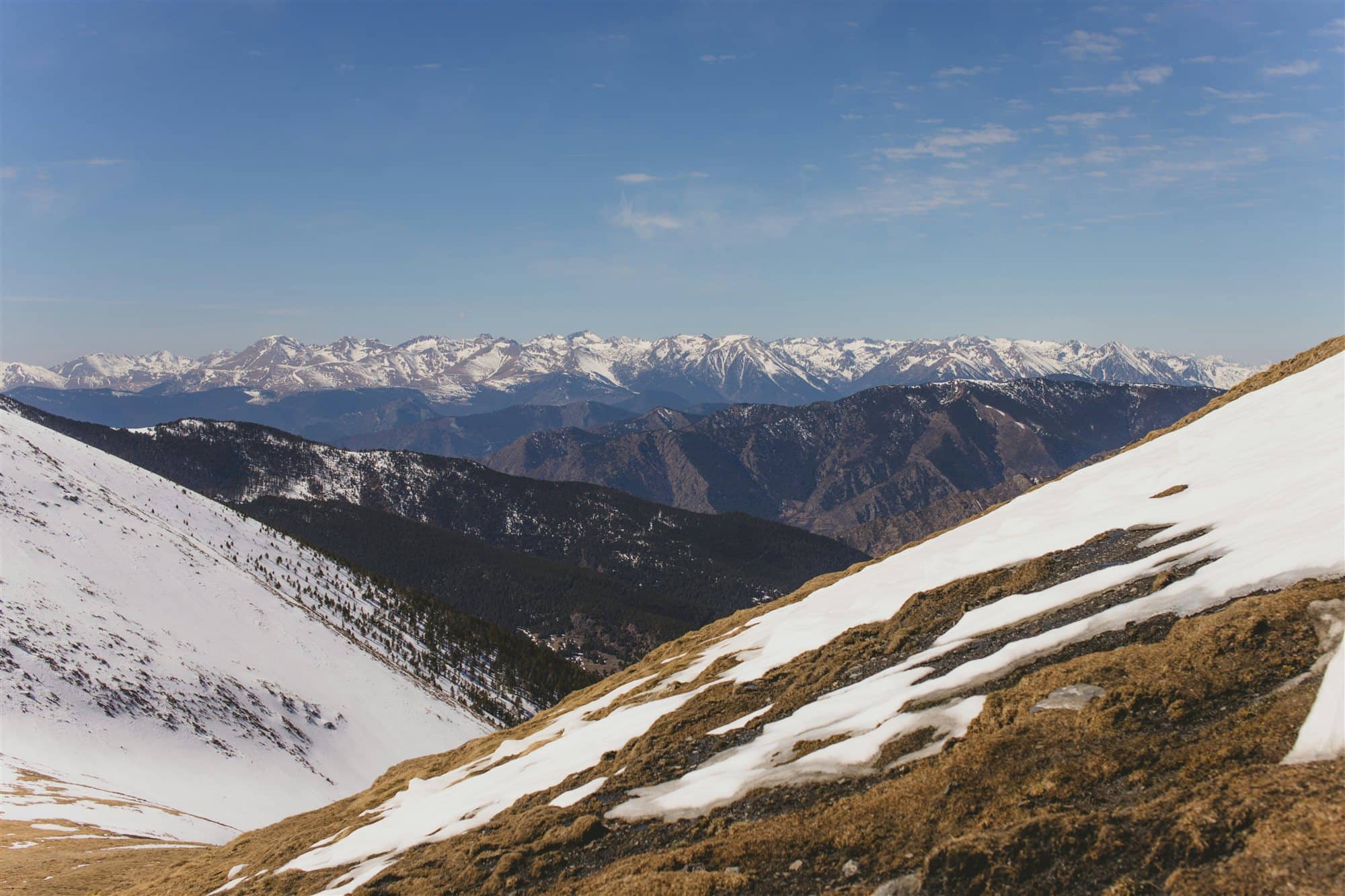 Panoràmica dels Pirineus nevats des d'un vessant de muntanya
