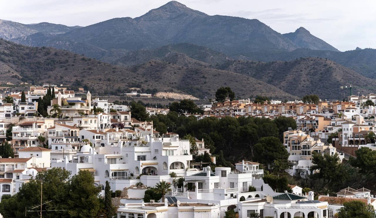 Casas blancas de Nerja bajo la Sierra de Almijara