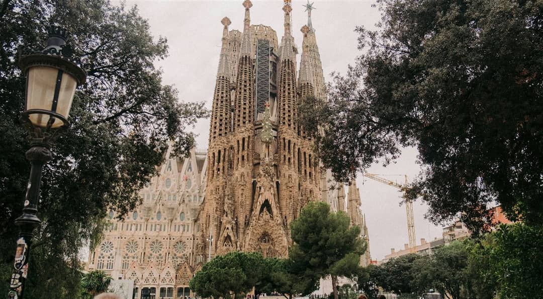 Die Geburtsfassade der Sagrada Família hinter Bäumen