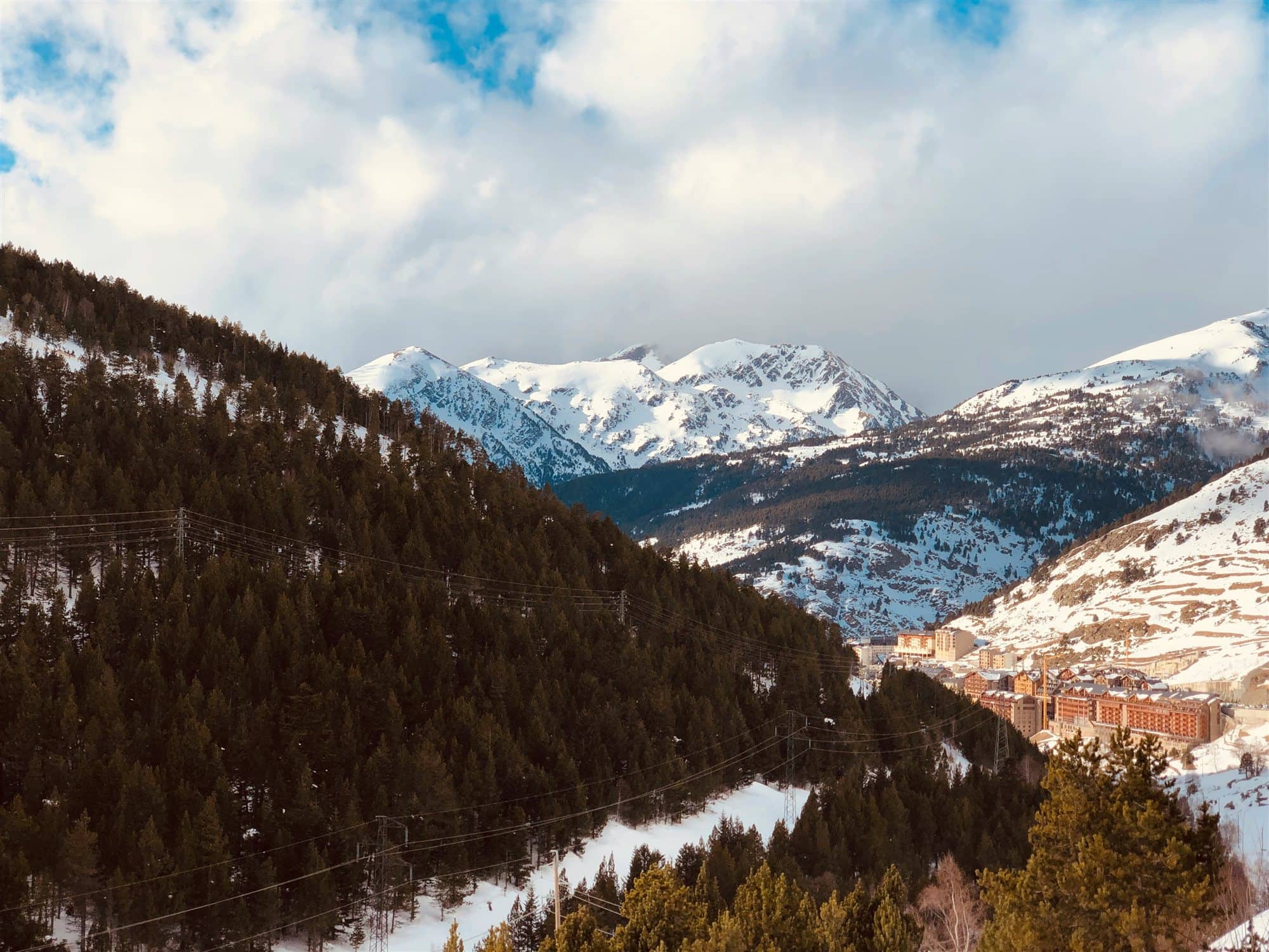 Muntanyes nevades sobre la vall i, a baix, els hotels del poble