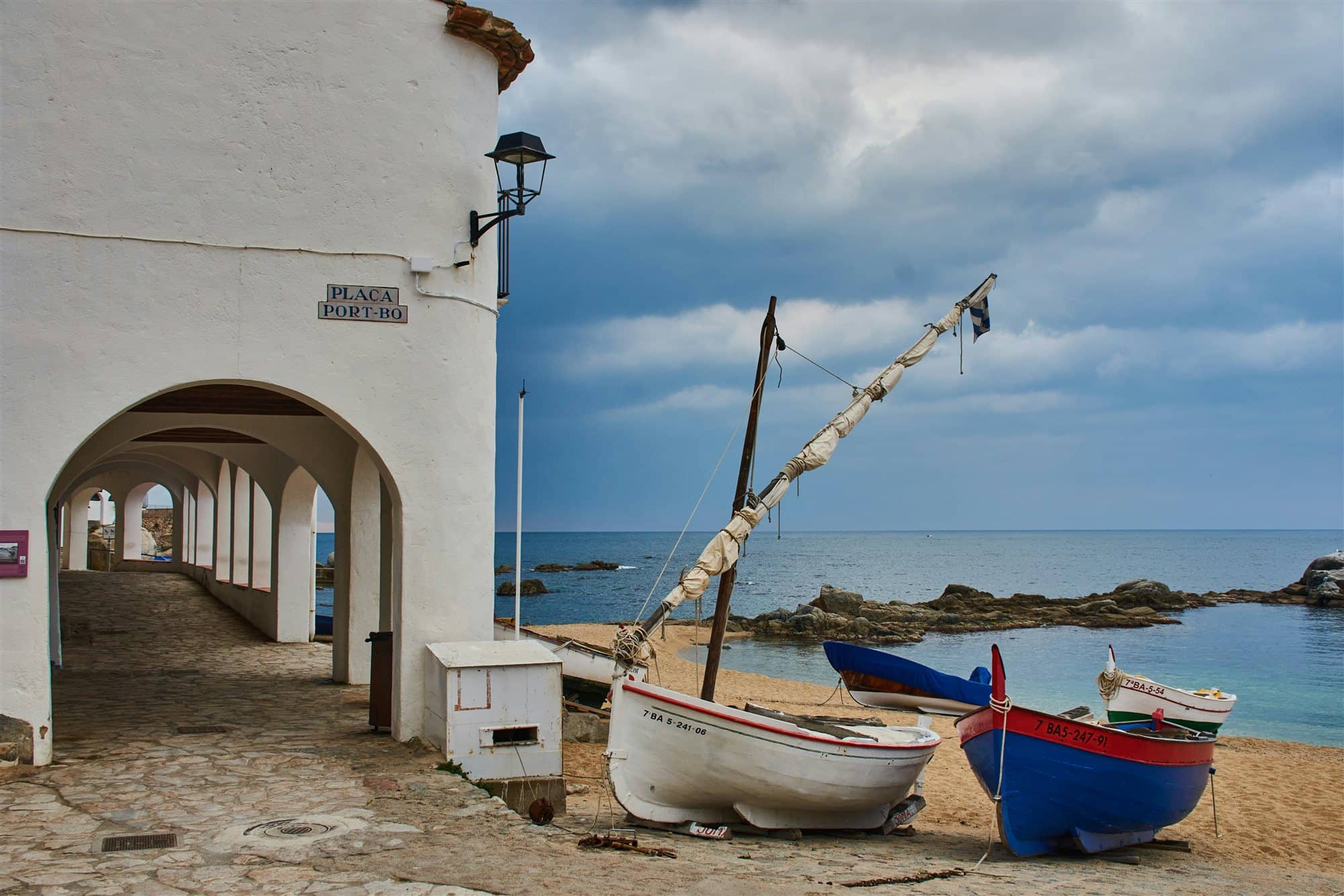 Les voltes del Port Bo a Calella de Palafrugell: arcs blancs i barques de pesca a la sorra