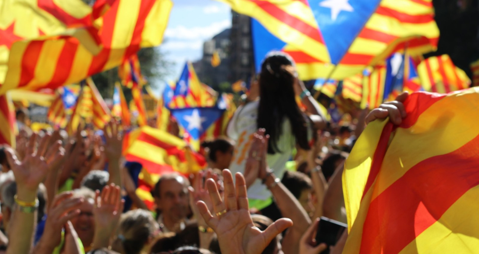 People carrying Catalan flags in a Barcelona street on La Diada