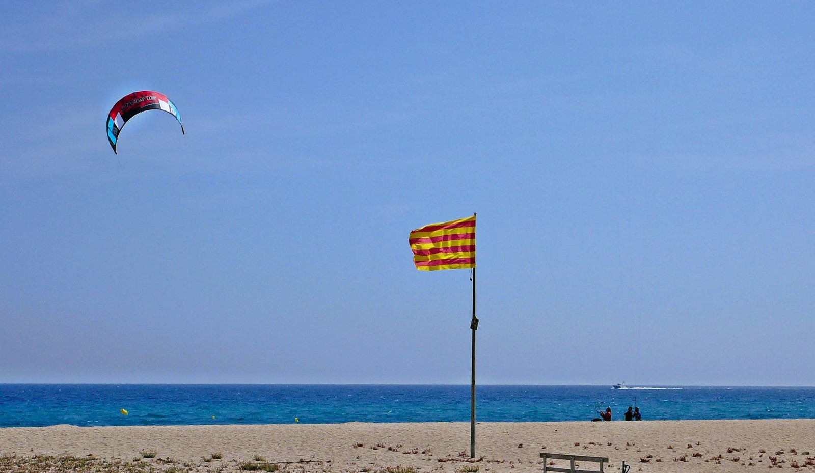 Wide beach of Malgrat de Mar: Catalan flag and a kite over the sea