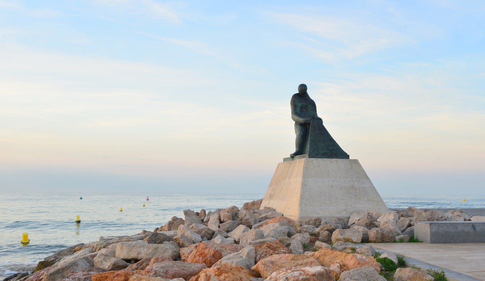 Monumento al pescador en el espigón de Salou al atardecer