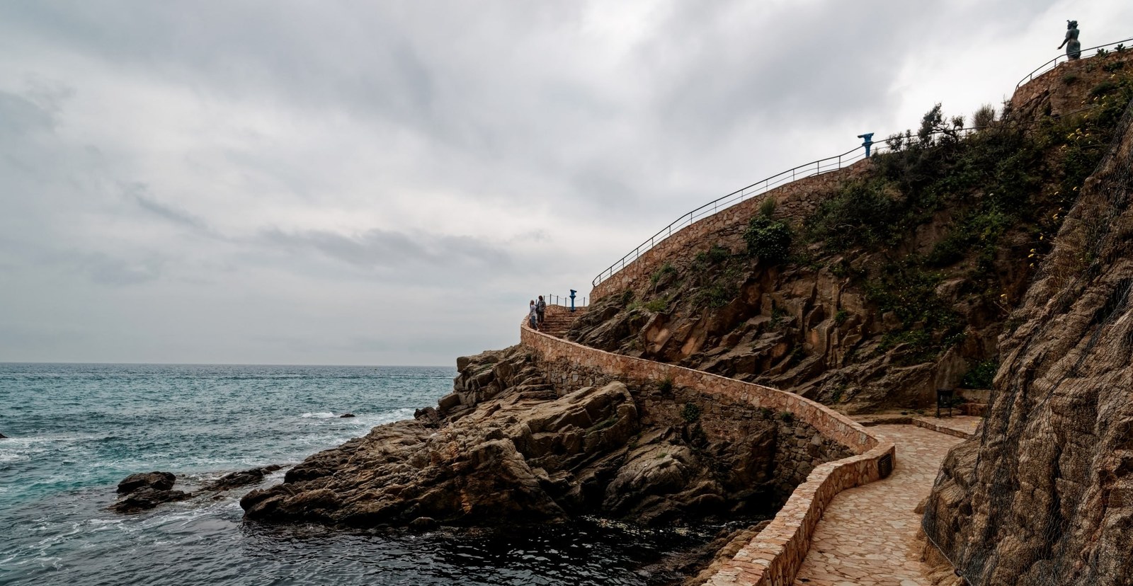Camins de Ronda: sender empedrat amb parapet de pedra sobre els penya-segats vora el mar