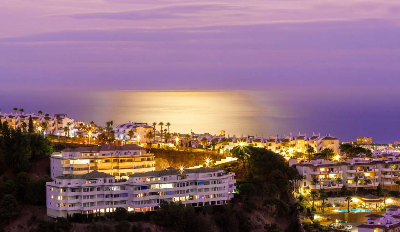 Wohnhäuser am Hang über dem Meer in der Dämmerung, Costa del Sol