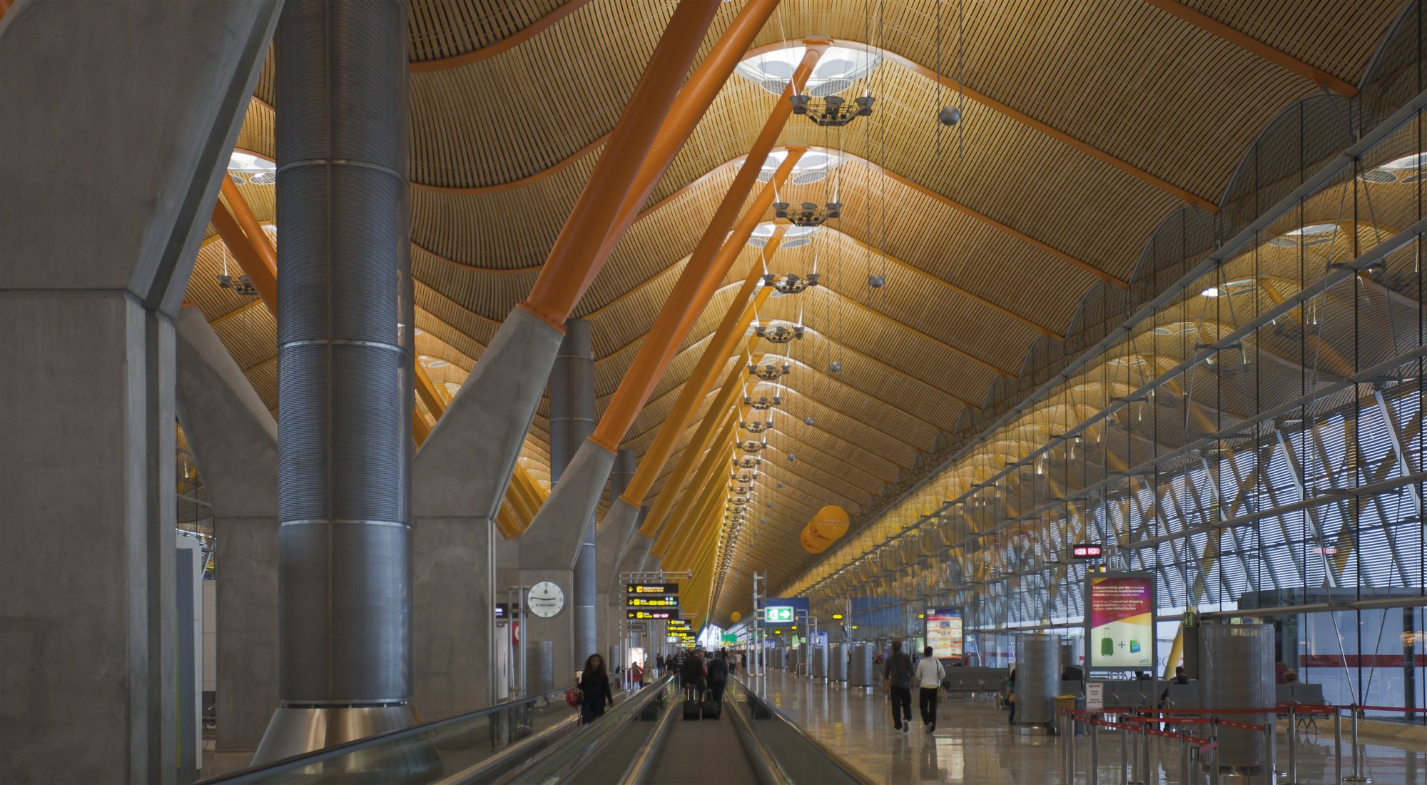 Vestíbul de la Terminal T4 de Barajas: sostre ondulat de fusta, pilars grocs i una cinta transportadora