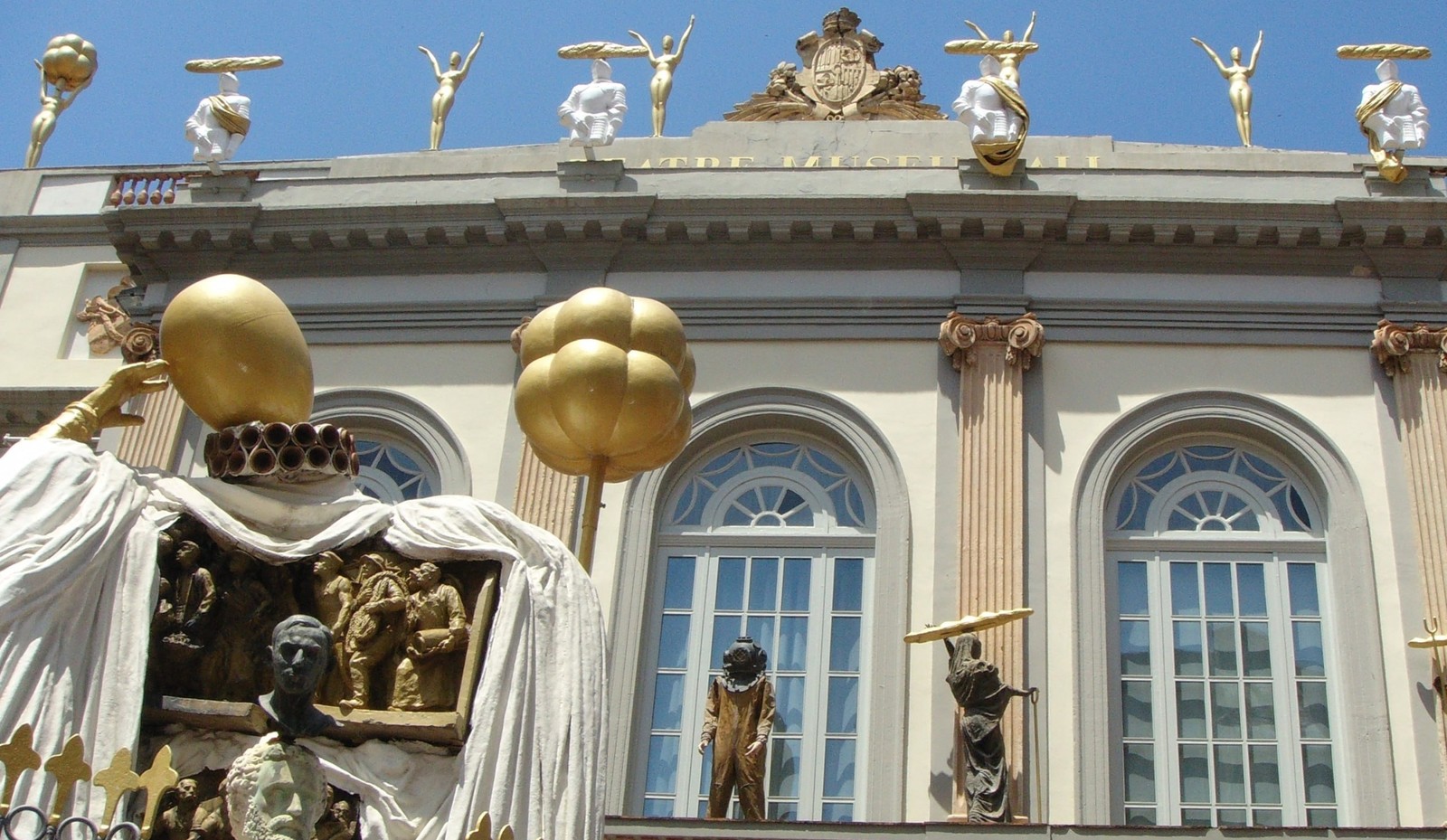 Figuras doradas con barras de pan en la cornisa del Teatro-Museo Dalí de Figueres