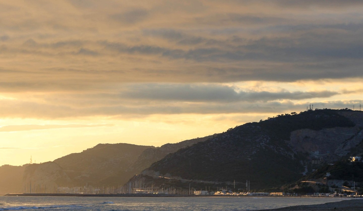 Castelldefels beach at sunset, the marina and the Garraf massif in the distance