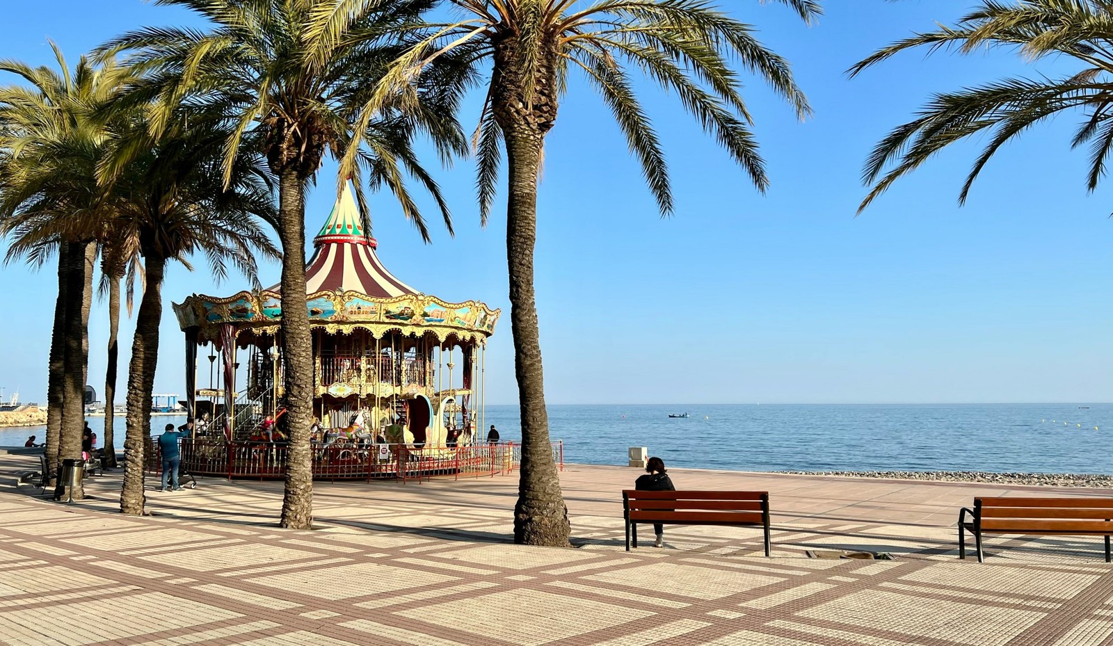 Tiovivo y palmeras en el paseo marítimo de Cambrils