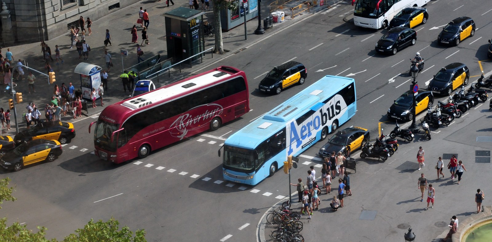 Aerobus und Taxis an der Plaça de Catalunya, mit Warteschlange an der Haltestelle