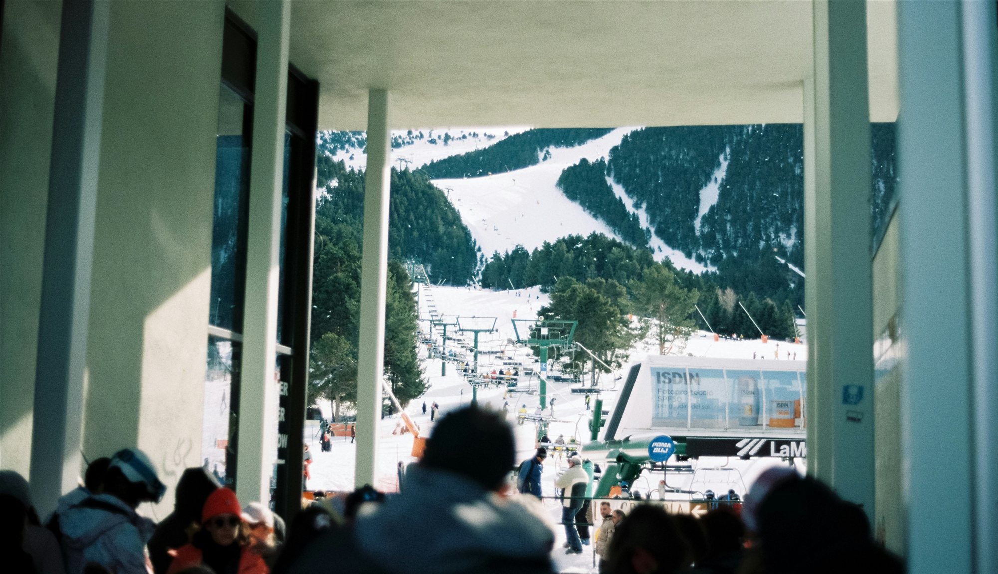 Talstation von La Molina: Schlange am Lift und Piste zwischen Kiefern