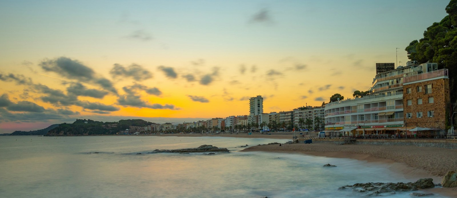 La platja de Lloret de Mar al capvespre: el passeig, els hotels i el cap rocós