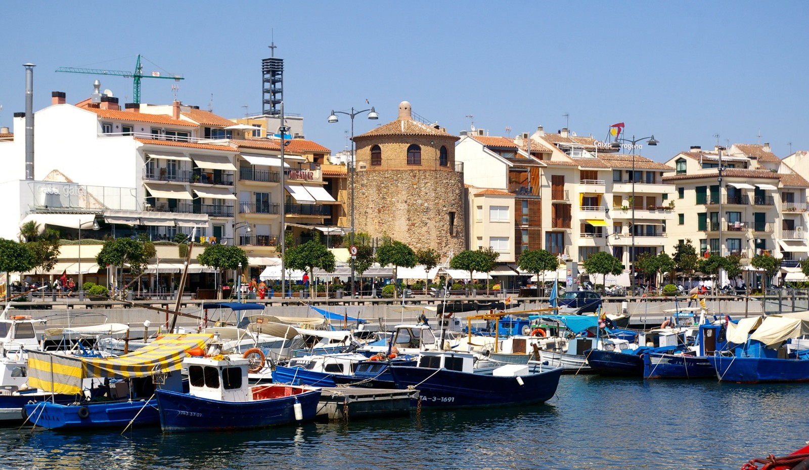 Barcas de pesca y la Torre del Port en el puerto de Cambrils