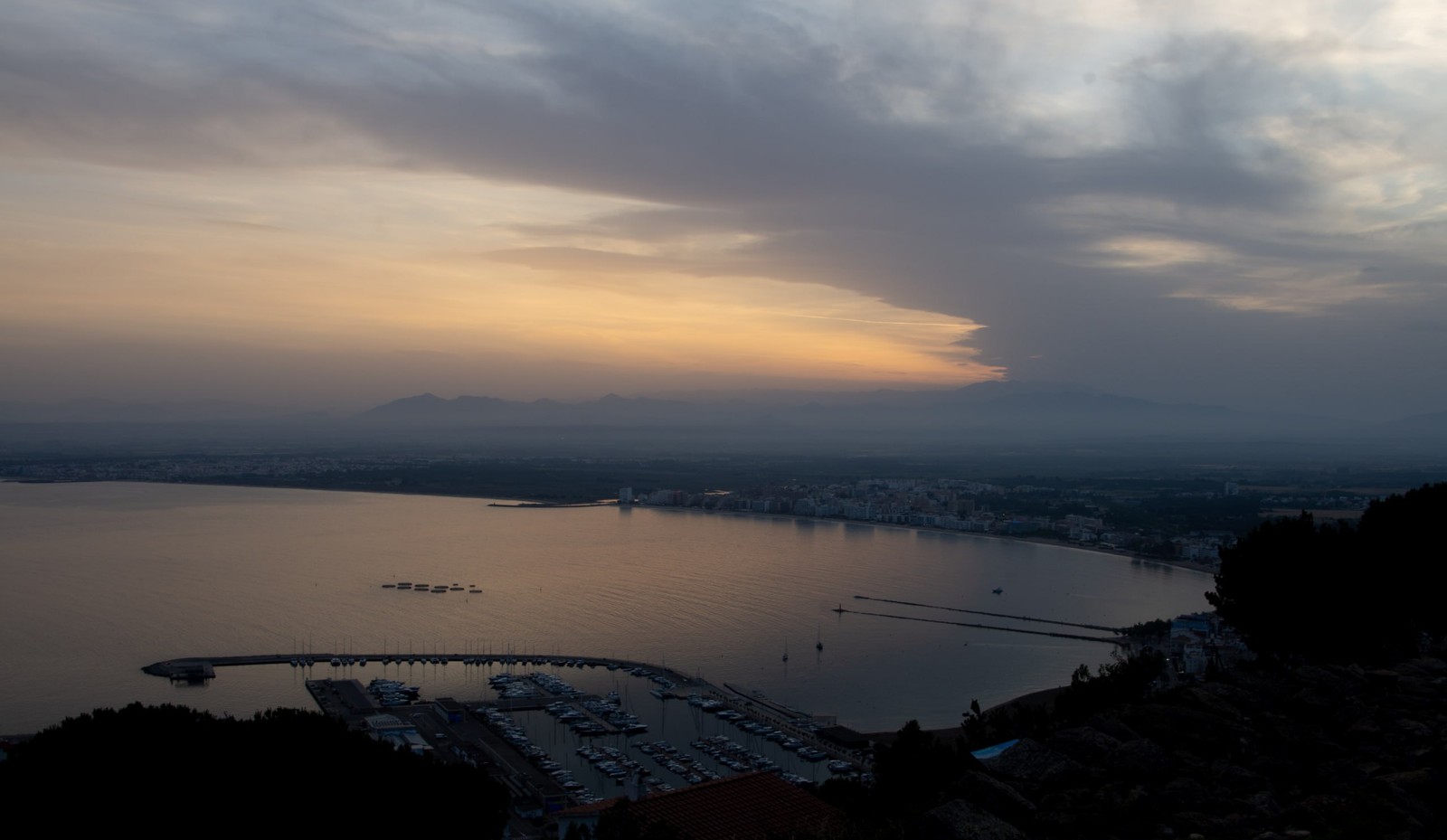 La badia de Roses i el port esportiu a la posta de sol