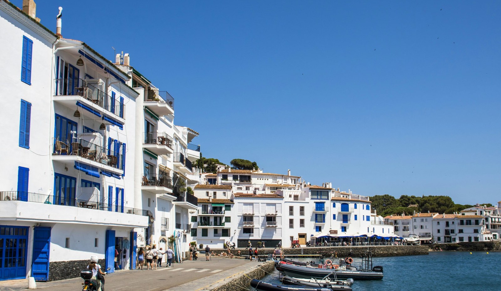 Front de mer de Cadaqués : maisons blanches aux volets bleus et barques au quai