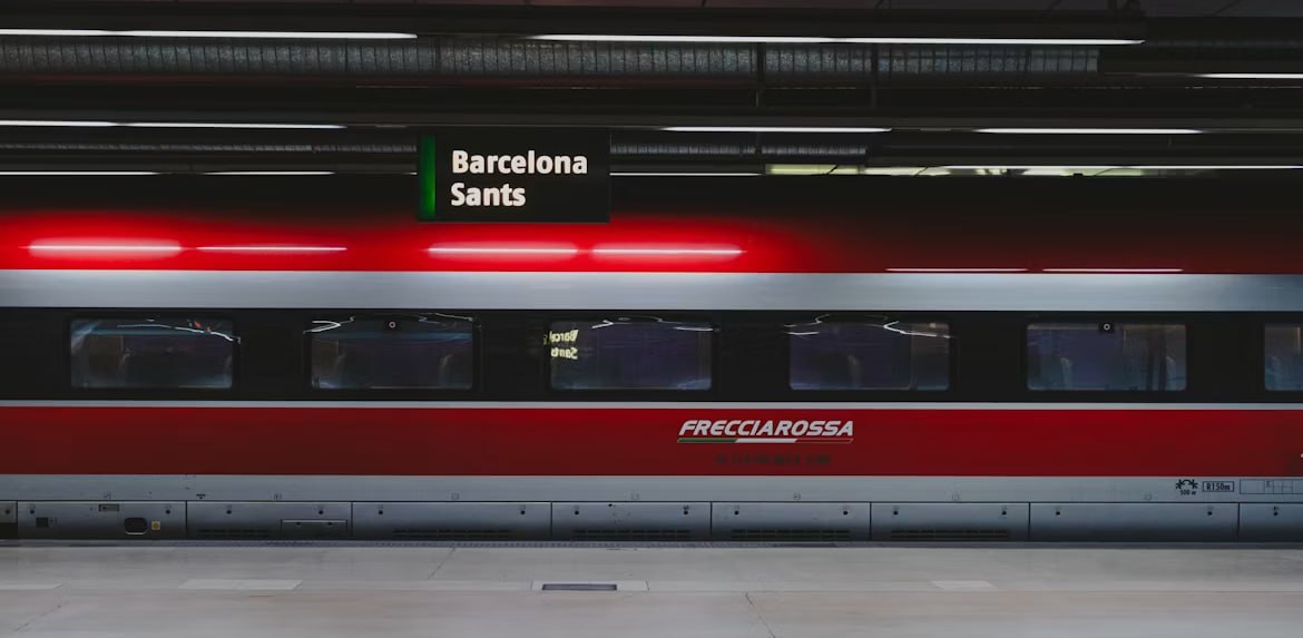 Hochgeschwindigkeitszug am Bahnsteig unter dem Schild Barcelona Sants