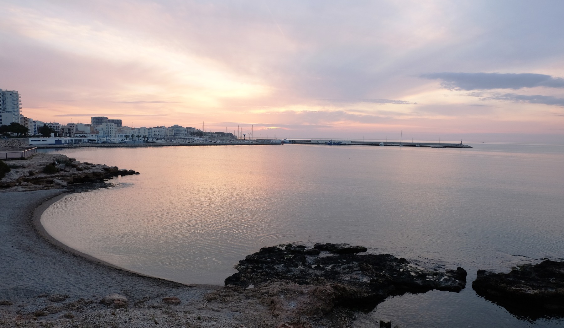 La badia de L'Ampolla a trenc d'alba, amb l'espigó del port al fons