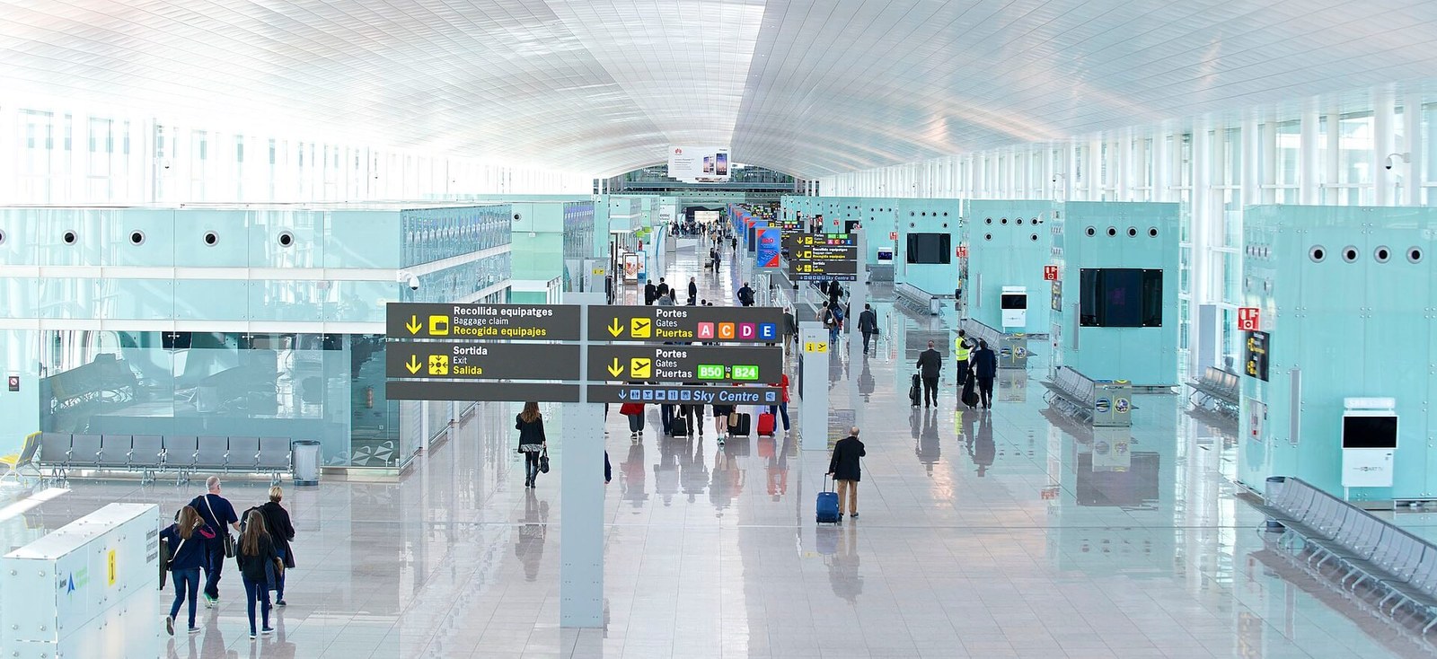 Die Halle von Terminal 1 in El Prat: Wegweiser zur Gepäckausgabe und zum Ausgang