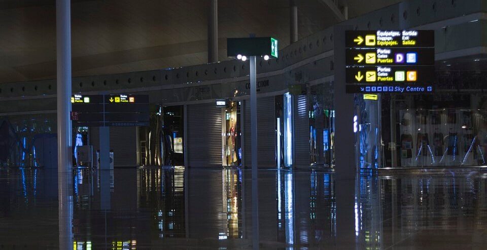 Wegweiser zum Ausgang und zur Gepäckausgabe im Terminal von El Prat bei Nacht